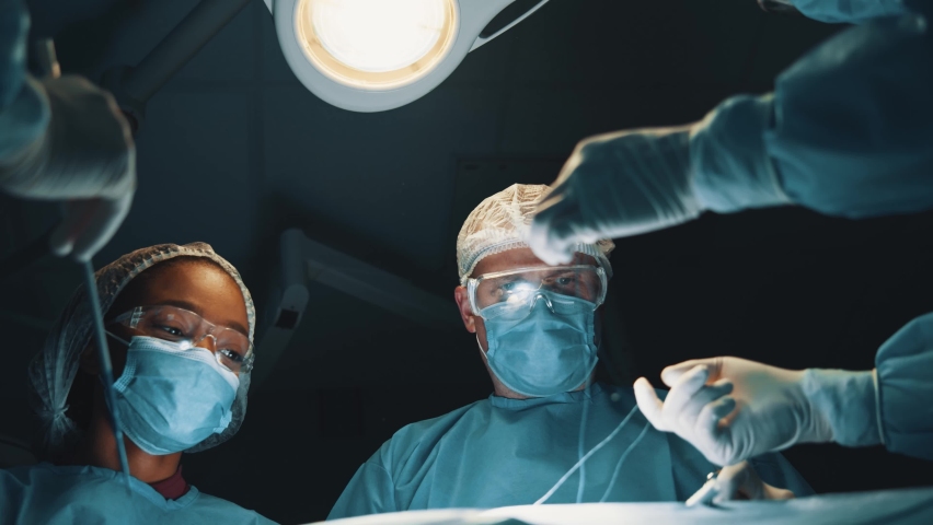 Professional surgeon performing operation with diverse nurses and interns. Group of medical workers doing surgery in operating room. Hospitals. Royalty-Free Stock Footage #1063120243