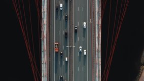 Drone shot of huge bridge with multi-lane road, many cars moving. Drone flying over bridge with river, transport on a highway road