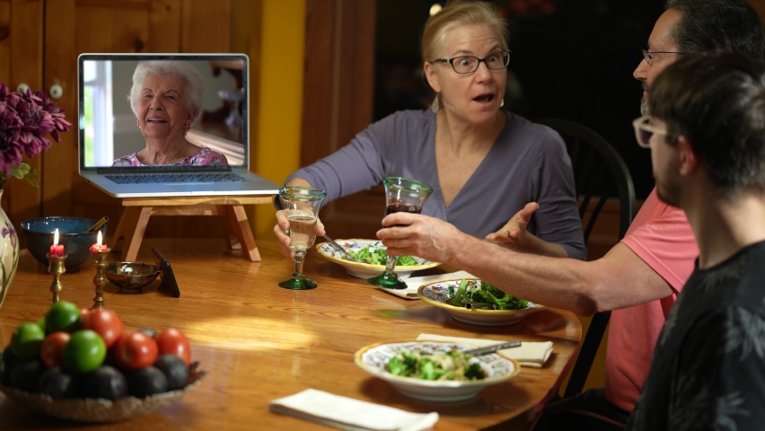 Family having a video call with grandmother during thanksgiving dinner, happy family greeting a remote guest. Concept of remote holiday meal. | Shutterstock HD Video #1063130434