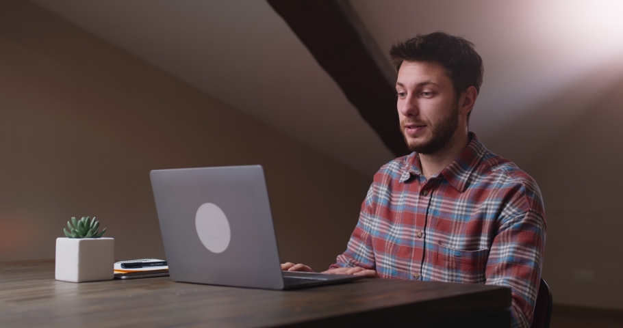 End of video conference. Young man waving hand good bye to laptop screen, saying goodbye to chat colleagues and closing laptop, sitting at workplace at home office Royalty-Free Stock Footage #1063132789