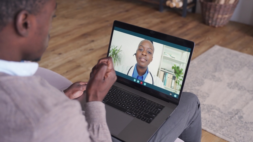 Male black patient on conference video call with female african doctor. Virtual therapist consulting young man during online appointment on laptop at home. Telemedicine chat, telehealth concept. | Shutterstock HD Video #1063133044