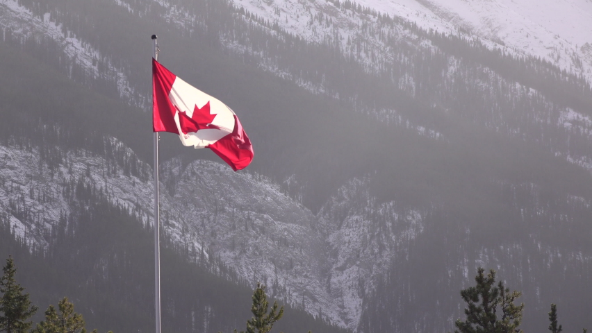 Canadian flag flying proud in Canadian Rockies 4k