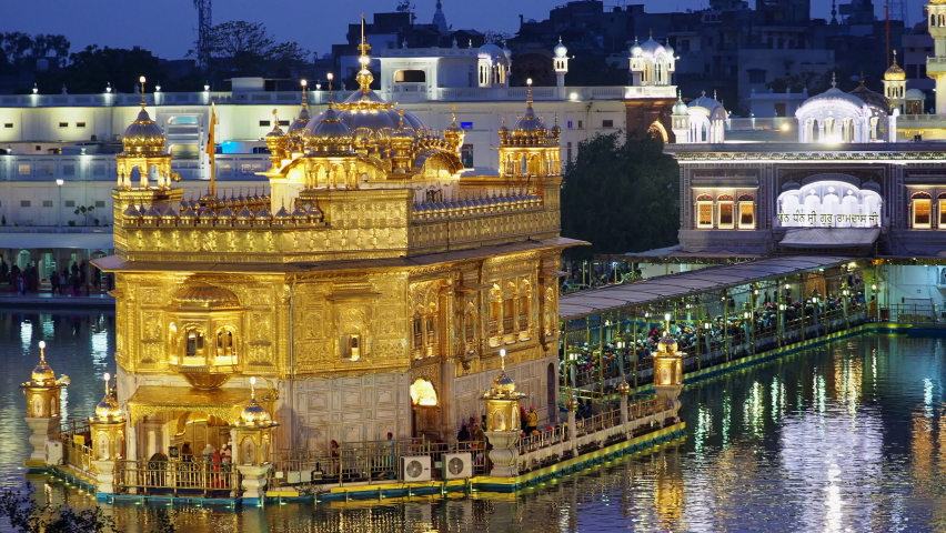 Sikh pilgrims visiting the Golden Temple aka Harmandir Sahib at dusk in Amritsar, Punjab, India. The Golden Temple is the Sikhs