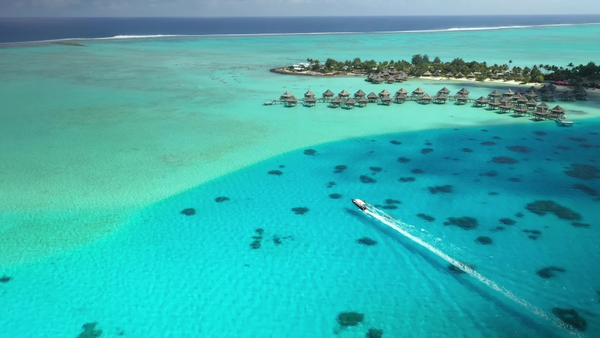 Aerial view Tahiti drone 4k. Bora Bora island. traditional canoe boat in blue lagoon. French Polynesia. Tropical paradise island. Exotic travel vacation getaway, romantic honeymoon destination. Royalty-Free Stock Footage #1063139548