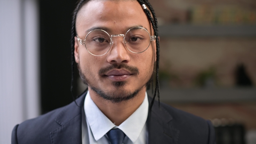 Close-up portrait of a young office worker looks confidently at the camera
