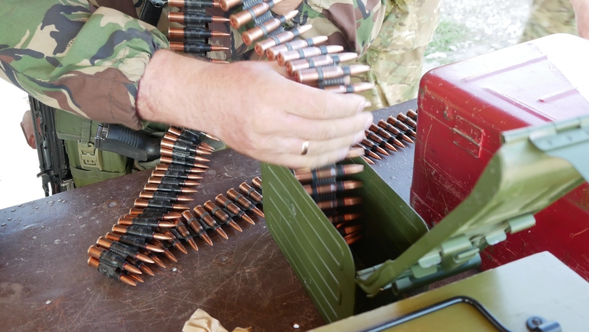 soldiers are preparing for war the bullets for the machine gun are loaded into the box. Military at the base. machine-gun belt.