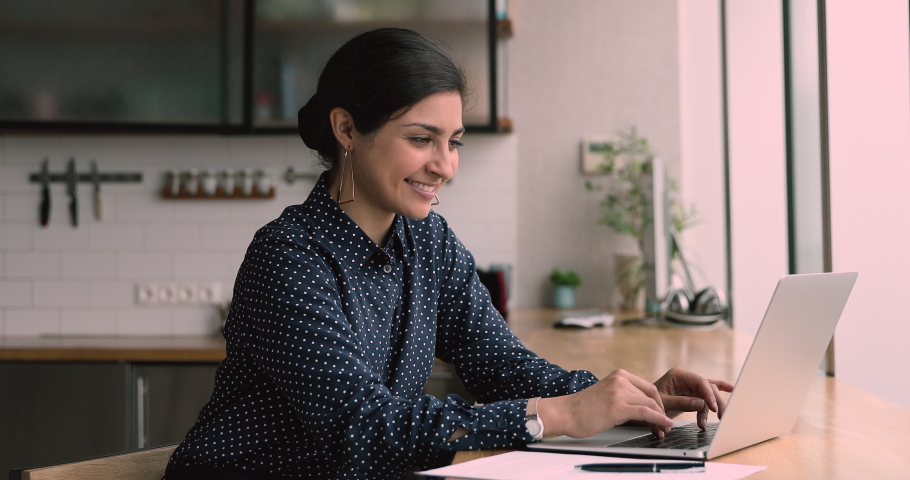 Indian woman sit in office or home kitchen use laptop check email read fantastic news. Offer sale good price, career promotion salary growth, on-line auction winner celebrate monetary victory concept | Shutterstock HD Video #1063141954