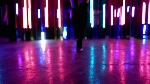 high heels dancing in nightclub, closeup view of female feet and slender legs, details of body