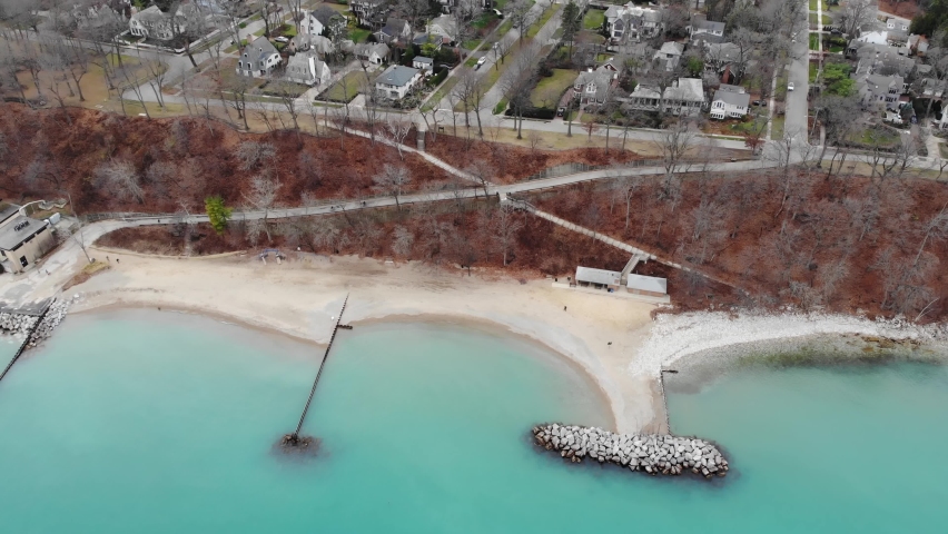 Lake Michigan shoreline aerial view. People walking in the park along lake Michigan shoreline. Blue water of lake Michigan shoreline north beach.