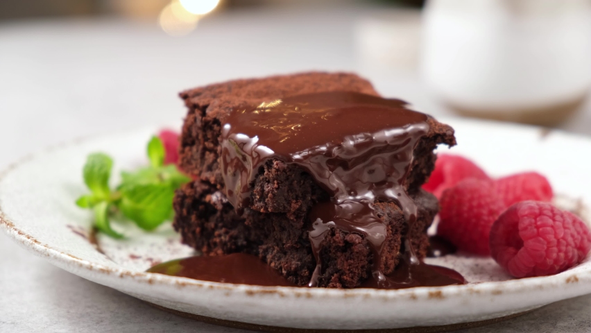 Eating brownie with fork. Taking bite of chocolate cake with chocolate icing and raspberries Royalty-Free Stock Footage #1063145557