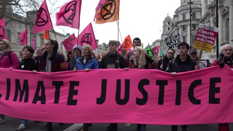 London , United Kingdom (UK) - 02 22 2020: People lead a protest with a large pink "Climate Justice" banner