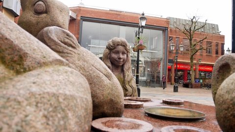 Warrington , United Kingdom (UK) - 02 27 2020: Mad hatter tea party granite carved sculpture in Warrington town Golden square Slow left dolly