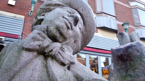 Warrington , United Kingdom (UK) - 02 27 2020: Low dolly under Mad hatter tea party granite carved sculpture in Warrington town Golden square