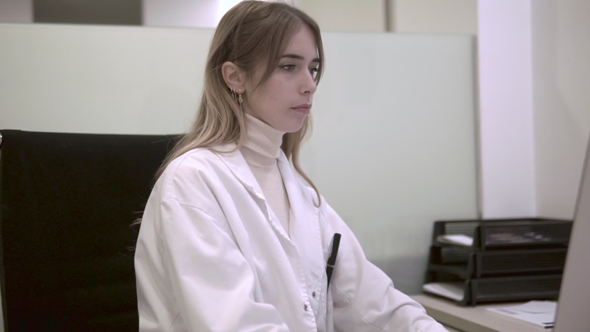 Young female doctor writing prescriptions at her office. Woman doctor writes a medical report in the office of the clinic