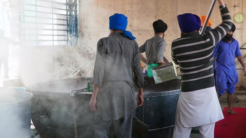 Amritsar, India - February 27, 2019: Sikh volunteers prepare dal (lentil soup) for thousands of pilgrims at the famous free kitchen (Punjabi: Langar ) at the Golden Temple in Amritsar, Punjab, India.