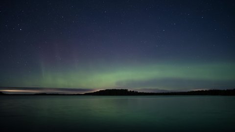 Aurora aka northern lights behind lake Savojärvi in Kurjenrahka National Park in Finland 