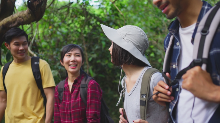 Group of young Asian man and woman friend traveling in the forest together. They are feeling fresh and relax in nature wild, looking and pointing the view then continue walking with happiness and fun. Royalty-Free Stock Footage #1063161949