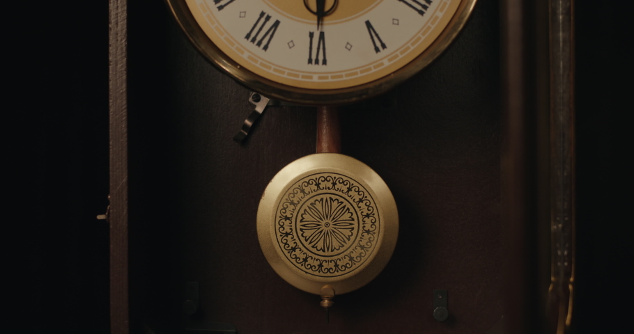 A vintage clock pendulum has been launched by the hand.