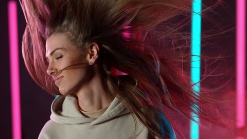 Slow motion of young woman rotating with her hair in neon lights, Filmed on high speed cinema camera.