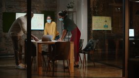 Diverse Multiethnic Team Wearing Face Masks During a Meeting Room Conversation Behind Glass Walls in Creative Office. Social Distancing Restrictions Concept in Work Place During Coronavirus Pandemic. - Powered by Shutterstock - Get 15% off with code: PIKWIZARD15