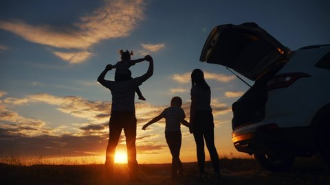 happy family children kid together standing next to car watching the sunset silhouette in park. family travel dream concept. happy family stand with sunlight their journey backs watching in the park