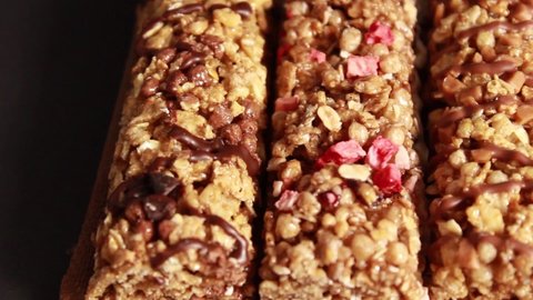 Energy bars with muesli, nuts and dried fruit on a black background. Close-up, selective shot.