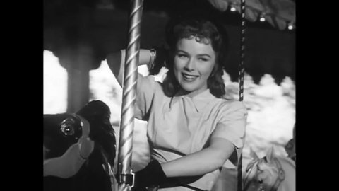 CIRCA 1949 - In this romance film, a couple rides a merry-go-round on a date.