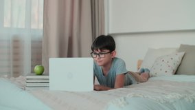 Using ChatGPT.Chat GPT.Artificial Intelligence.Home Isolation, Online Learning, Remote Work, New Education. Child doing homework using online technology while lying on the bed at home