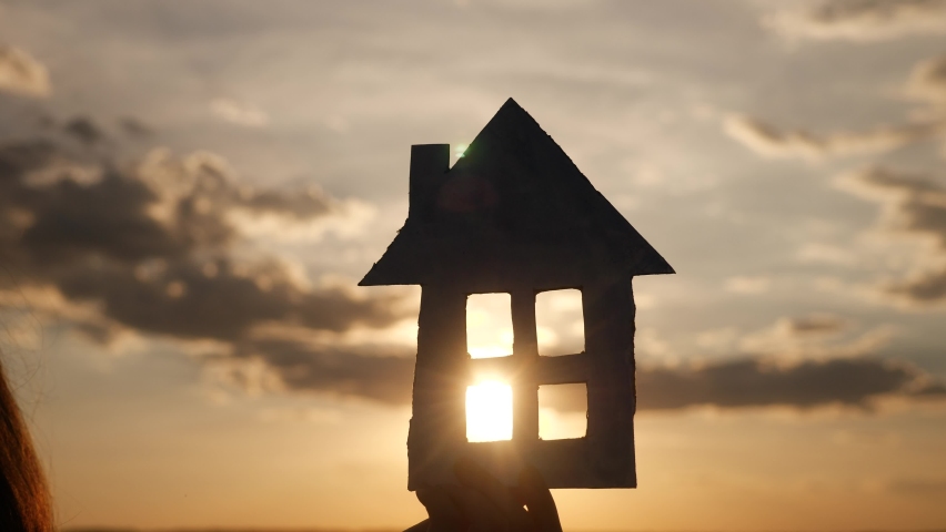 paper house in hand silhouette at sunset. insurance mortgage home market concept. handmade paper house in the sun lifestyle at sunset silhouette. dream of home accumulation symbol Royalty-Free Stock Footage #1063189273