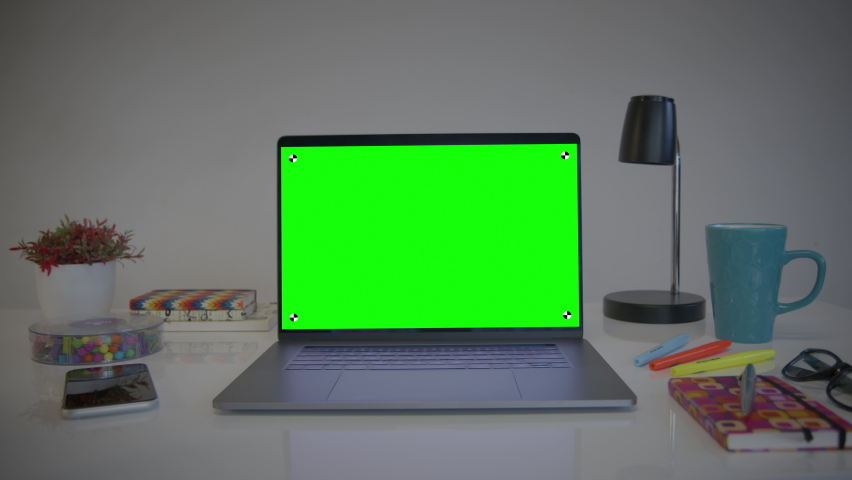 Laptop Computer Showing Green Chroma Key Screen. Colorful desk elements. Dolly in. Home office. Track points with perspective corner pin.    | Shutterstock HD Video #1063190662