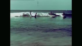 CIRCA 1960s - Surfers jostle for waves at a busy spot at Malibu beach, followed by scenes of surfers repeatedly failing to catch a wave.
