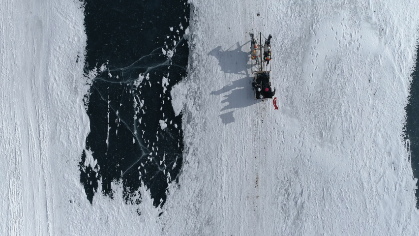 Aerial top view of frozen lake and Horse carriage