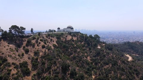 LOS ANGELES, CALIFORNIA - CIRCA 2020 - Good rising aerial of the Griffith Park observatory with downtown Los Angeles distant.