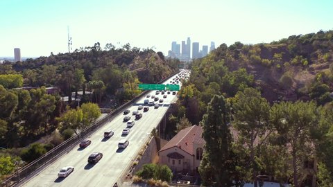 LOS ANGELES, CALIFORNIA - CIRCA 2020 - Aerial freeway cars travel along the 110 freeway in Los Angeles through tunnels and towards downtown skyline.