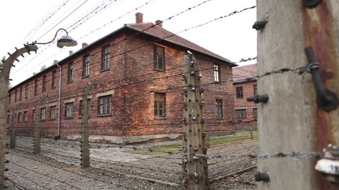 Auschwitz Poland Push Slowly By Barbed Wire Fence With Building In Background