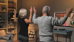 old couple exercising workout at home class course online. elderly people healthy lifestyle does exercise training at home watching an internet lesson live streamed from their personal trainer.