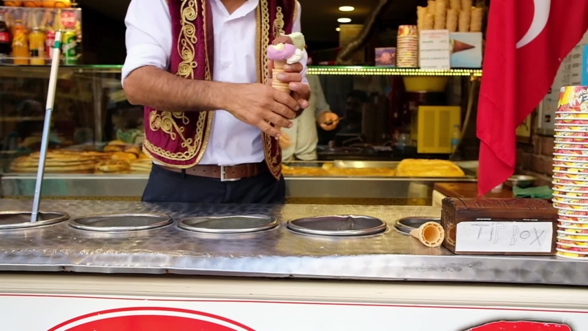 Close up view of seller making classic fun tricks with customer. Traditional turkish dondurma is a mastic ice cream. Slow motion | Shutterstock HD Video #1063211305