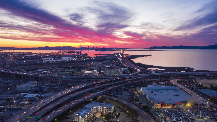 Aerial hyperlapse of fast moving freeway traffic at sunset showing cars and light streaks 4K, Oakland, San Francisco Bay Area, California