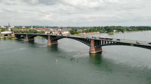 Aerial view overlooking cars on a the Theodor Heuss bridge, cloudy day, on Rhein river, in Mainz, Germany - rising, drone shot