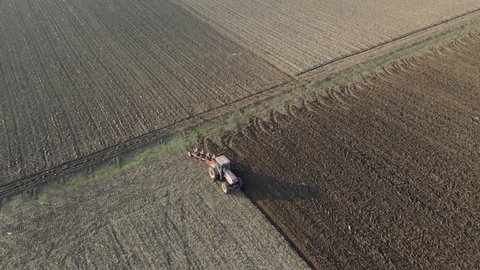 Dramatic reveal of tractor ploughing and surrounding farmlands - Romania.