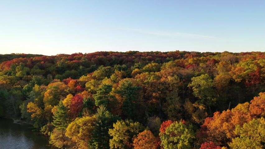 Drone shot elevating above the lushes, colorful autumn forest in Started Rock State Park at Eagles cliff in Illinois.