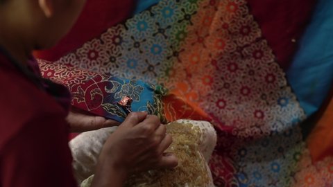close up, women make batik fabrics in a traditional, flexible way.