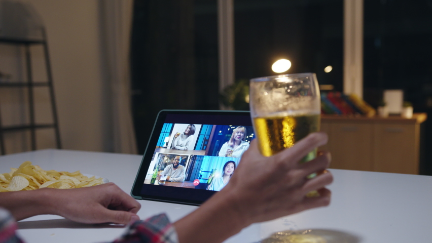 Young Asia lady drinking beer having fun happy moment night party event online celebration via video call in living room at home at night. Social distancing, quarantine for coronavirus prevention. Royalty-Free Stock Footage #1063219060