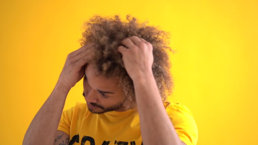 Slow motion shot of man with afro and hands in hair