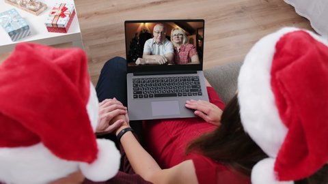 Young Couple Celebrating Christmas at Home. Enjoying Video Call With Parents by Laptop. Selective Focus