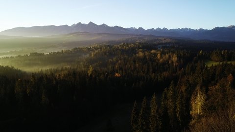 Mountain aerial, epic view. Aerial view of mountain landscape with morning fog, Tatra high mountains in the sunny morning after sunrise. Drone footage of misty forest and magical alpine scenery