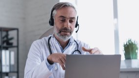 Portrait of Confident Mature Doctor holding Seminar, Webinar, Lecture. Medical Mentor holding Video-Call Class. Doctor is wearing a Headset, holding a Medical Online Conference. Quarantine.