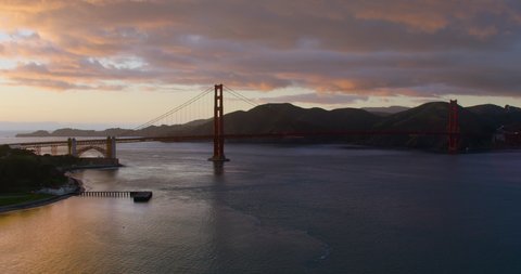 Aerial view of the magnificent Golden Gate Bridge during sunset. This bridge connects the San Francisco peninsula to Marin County. US route 101 and SR 1 full of cars. Shot on Red 8K.