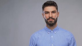 people and gesture concept - video portrait of happy smiling young man with beard showing thumbs up over grey background