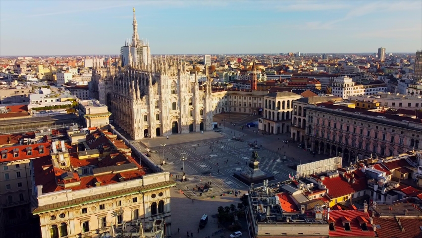 Aerial view of Piazza Duomo in front of the gothic cathedral in the center. Drone view of the gallery and rooftops during the day. Flight over the city. People in the city. Milan. Italy 2020 Royalty-Free Stock Footage #1063255942